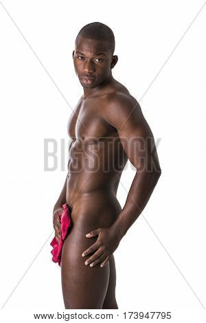 Totally naked young black male bodybuilder hiding genitalia with hands, smiling at camera, isolated on white background