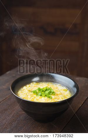 Asian porridge bowl on rustic wooden table background.
