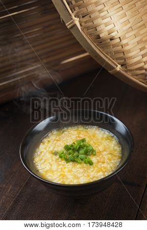 Asian style porridge bowl on rustic wooden table background.