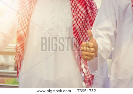 Arab middle eastern businessman giving thumb up as sign of success business teamwork concept.