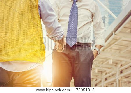 Success and Happiness Team Concept Businessman and business engineering handshake at city background.