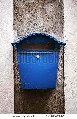 Old mailbox is mounted on a wall.