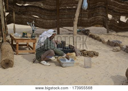 Eastern Desert Egypt - January 24 2013: Eastern Desert Egypt - January 24 2013: Bedouin man preparing food in the desert of Egypt