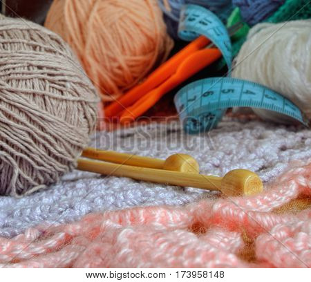 Tips of bamboo spokes against the background of tools and materials for knitting. Small depth of sharpness. In the room. Still life. Color. Stock photo.