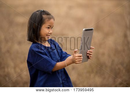 asian young girls in rural areas are using the iPad a selfie herself