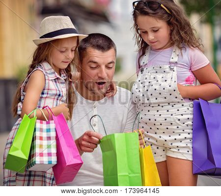 Happy father with children have a successful day of shopping