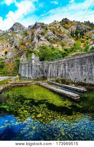 Mediterranean landscape. Overhanging cliffs, medieval city walls and river.