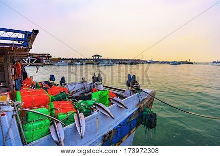 Old boat with sunset and waterfront area during sunset