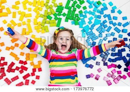 Child Playing With Rainbow Plastic Blocks Toy