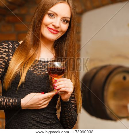Woman Tasting Wine In Rural Cottage Interior