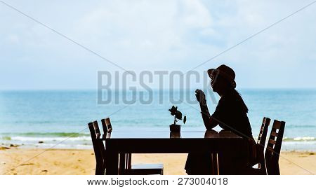 Single Asian Young Woman Sitting At Dining Table On Beach