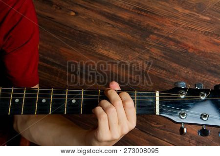 Hand Of Man Playing Six-string Guitar On Wooden Background. Template For Concert Poster