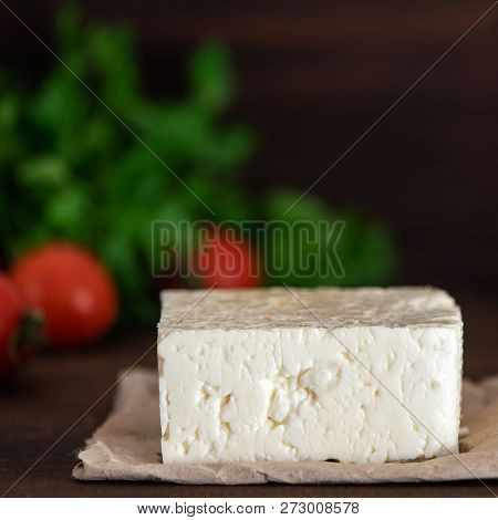 Large Piece Of Feta Cheese On Dark Wooden Table. Selective Focus.