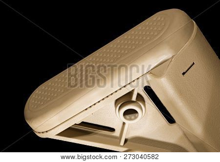 Tan Colored Recoil Pad From An Ar-15 On A Black Background