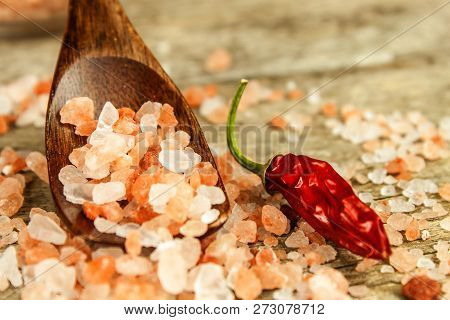 Pink Salt From The Himalayas On Wooden Background. Pile Of Pink Himalayan Salt. Salt And Chilli Pepp