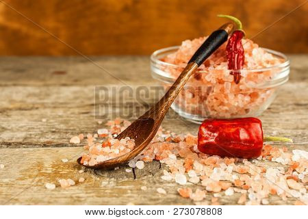 Pink Salt From The Himalayas On Wooden Background. Pile Of Pink Himalayan Salt. Salt And Chilli Pepp