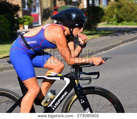 St Neots, Cambridgeshire, England - July 01, 2018: Female Triathlon Competitor On Bicycle Taking Ene