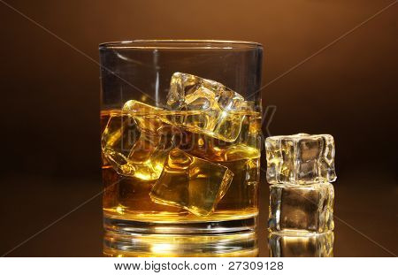 verre de whisky et de la glace sur fond marron