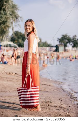 Smiling Young Woman With Bag On Beach