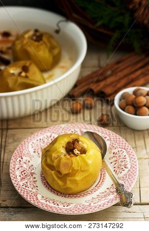 Baked Apples With Raisins, Hazelnuts And Cinnamon On Wooden Background. Rustic Style.