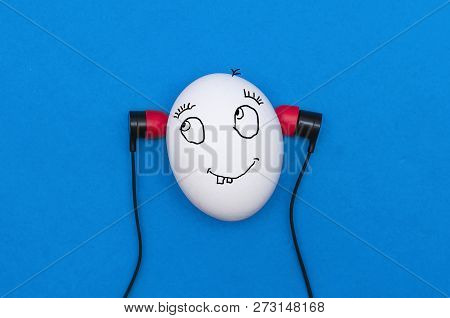 Funny Chicken Egg Like A Man Head With Earphones Is Listening A Music Isolated On The Blue Backgroun