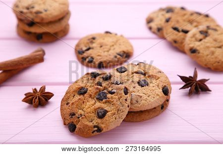 Delicious Chocolate Cookies On Brown Background. Chocolate Cookies And Cinnamon Sticks.