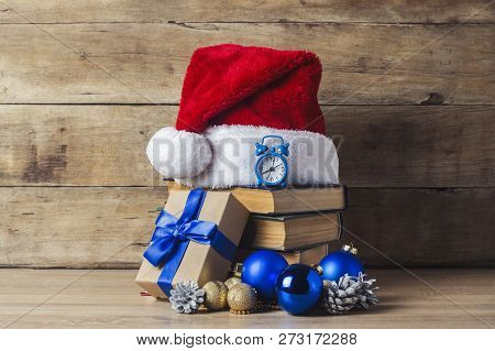 A Stack Of Books, Santa Clauss Cap, An Alarm Clock, Cones, Christmas-tree Decorations, Gift Boxes On