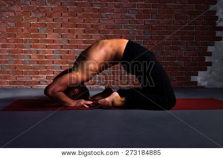Man Doing The Pose Of Yoga Kapotasana