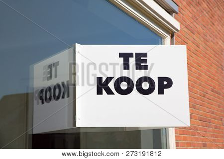 White Marketing Board On Window Of Home With Text Te Koop Or For Sale