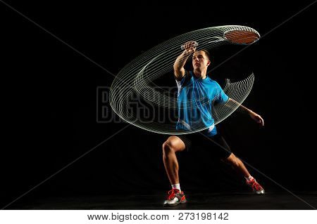 Young Man Playing Badminton Over Black Studio Background. Fit Male Athlete Isolated On Dark With Led