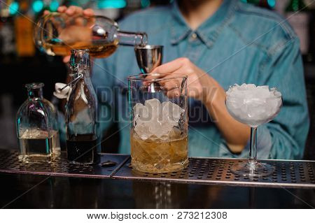 Female Bartender Pouring To The Steel Jigger An Alcoholic Drink