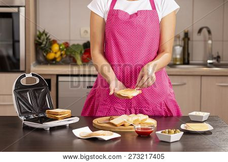 Detail Of Female Hands Adding A Cheese Slice On A Sandwich; Woman Making Hot Sandwiches In A Sandwic