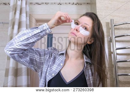 Tired Woken Woman Removes Patches From The Eyes In The Bathroom.