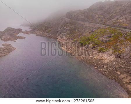 Lake In Stone Rocky Mountains, Misty Foggy Day. Norway Summer Landscape. Norwegian National Tourist 