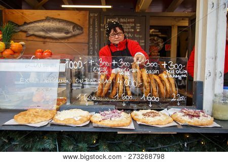 BUDAPEST, HUNGARY - December 8, 2018:  Visiting the Christmas Market in Budapest. Traditional street food - Langos doughnut.