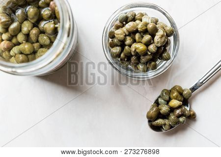 Jar Of Capers In Glass Bowl.