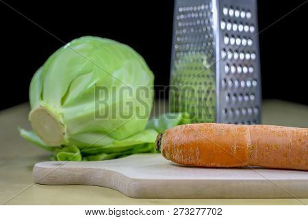 Fresh Carrot Grated On A Metal Kitchen Grate. Vegetables Prepared For Salad With A Meal On The Kitch