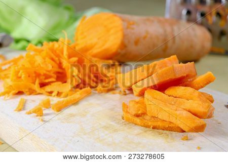 Fresh Carrot Grated On A Metal Kitchen Grate. Vegetables Prepared For Salad With A Meal On The Kitch