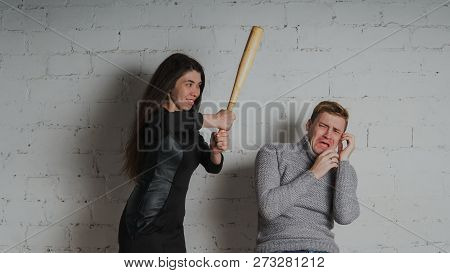 A Girl Swings A Baseball Bat At A Guy. A Student Bully Threatens A Man. Concept: Litter In The Famil