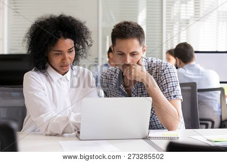 Serious Diverse Office Colleagues Discussing Online Project Resu