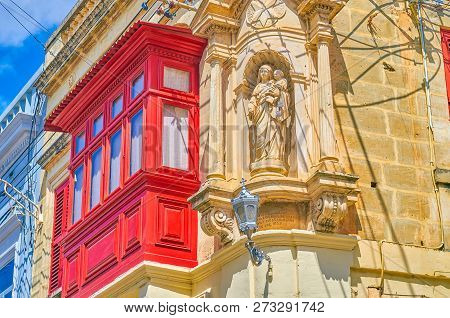The Beautiful Maltere Red Balcony Neighbors With The Statue Of Virgin Mary And The Child On The Cort