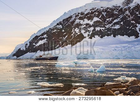 Touristic Antarctic Cruise Liner Drifting In The Lagoon Among The Icebergs With Glacier In Backgroun