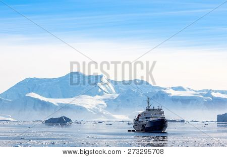 Touristic Antarctic Cruise Liner Drifting In The Lagoon Among The Icebergs With Glacier In Backgroun