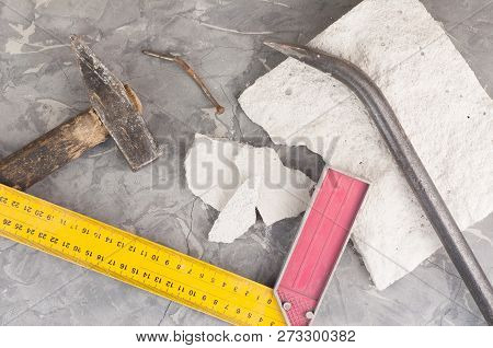 Broken Stone And Dirty Old Hammer With Wooden Handle And Rust Nail And Metal Nail Puller And Yellow 