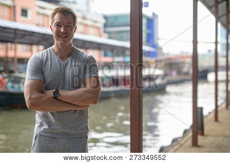 Young Happy Tourist Man Smiling At The Local Pier In Bangkok