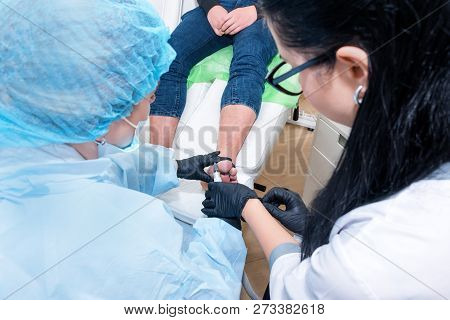 Podology Treatment. Podiatrist Treats Foot. Podiatry Doctor Or Dermatologist Treats The Patient In M