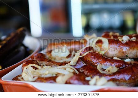 Fried Ukrainian Sausages In Food Market On The Street. Street Food And Outdoor Cooking Concept