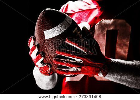 American football player holding rugby ball, Close-up