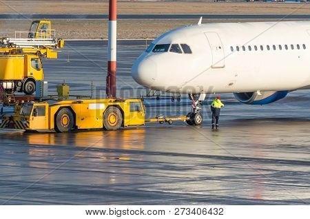 The Pushback Tractor Is Towing The Aircraft To A Parking Lot, Aviation Marshall.