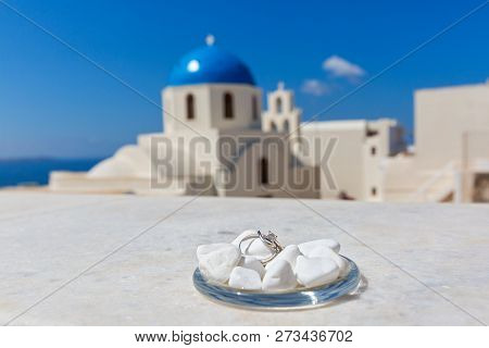 Wedding Rings On The Background Of The Dome Church In Santorini